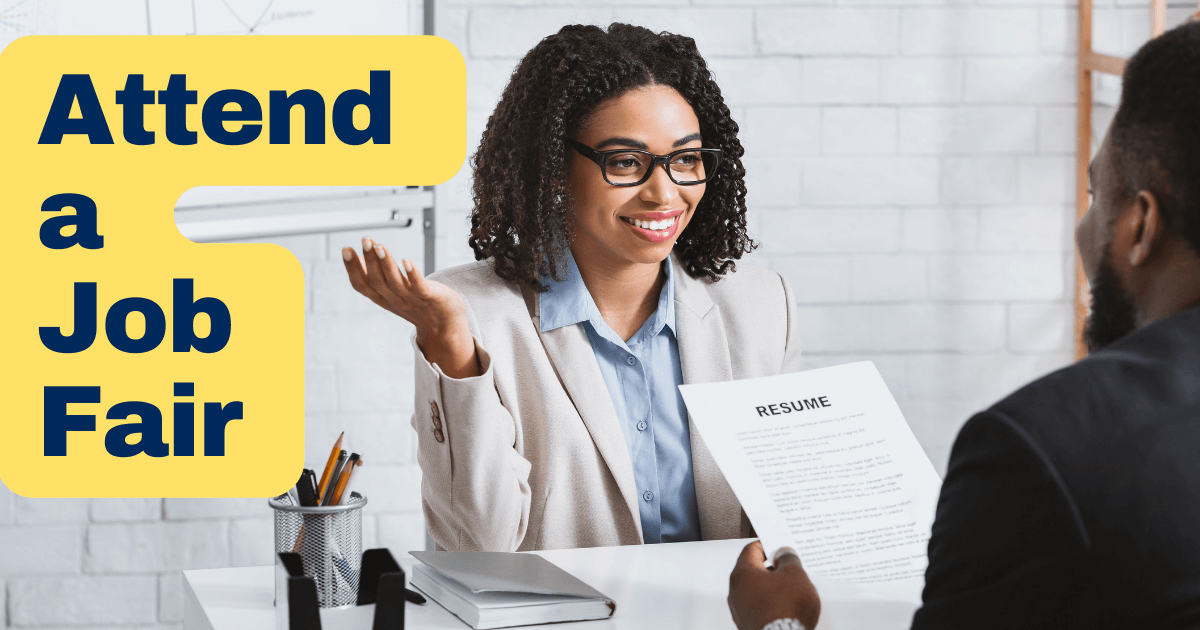 Two people at a desk sitting across from each other. Wording at left reads "Attend a Job Fair" on a yellow background.